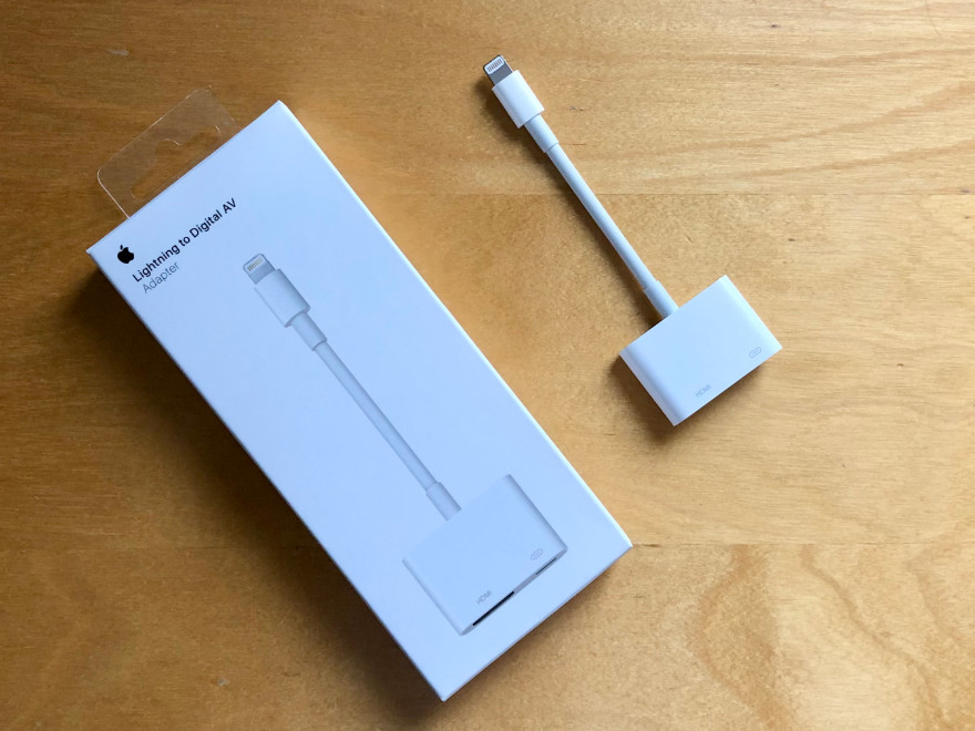Apple Lightning-to-Digital-AV-Adapter inklusive Originalverpackung nebeneinander auf einem Tisch.