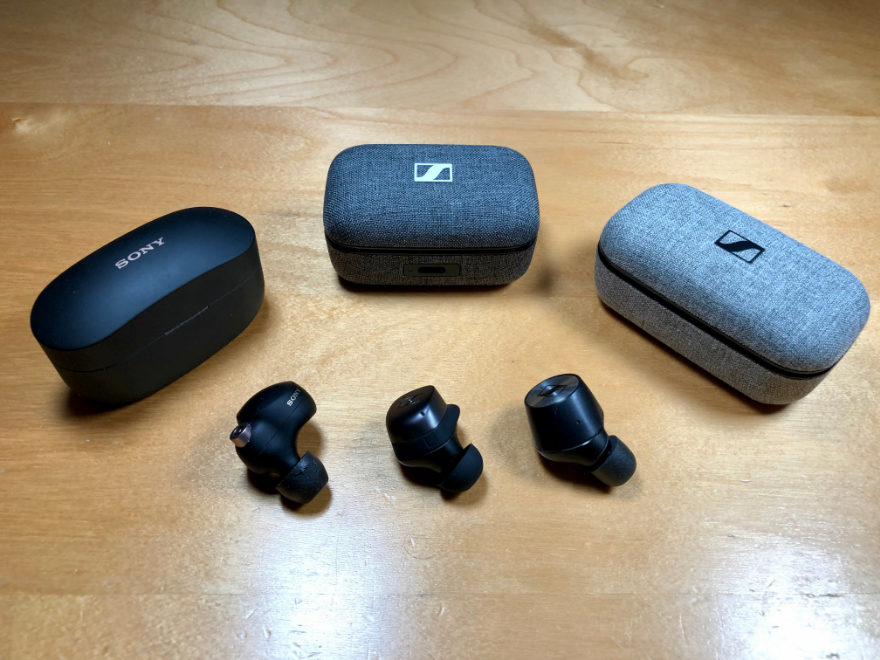 Cases und rechter Ohrhörer der Sony WF-1000XM4, Sennheiser Momentum True Wireless 3 und 1 auf einem Tisch.