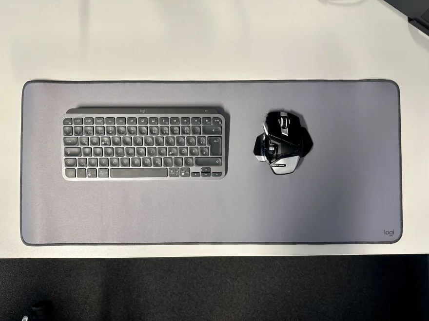Die Logitech Desk Mat von oben auf einem Tisch liegen. Darauf platziert die Logitech MX Keys Mini (Tastatur) und eine Mad Catz R.A.T. DWS (Maus).